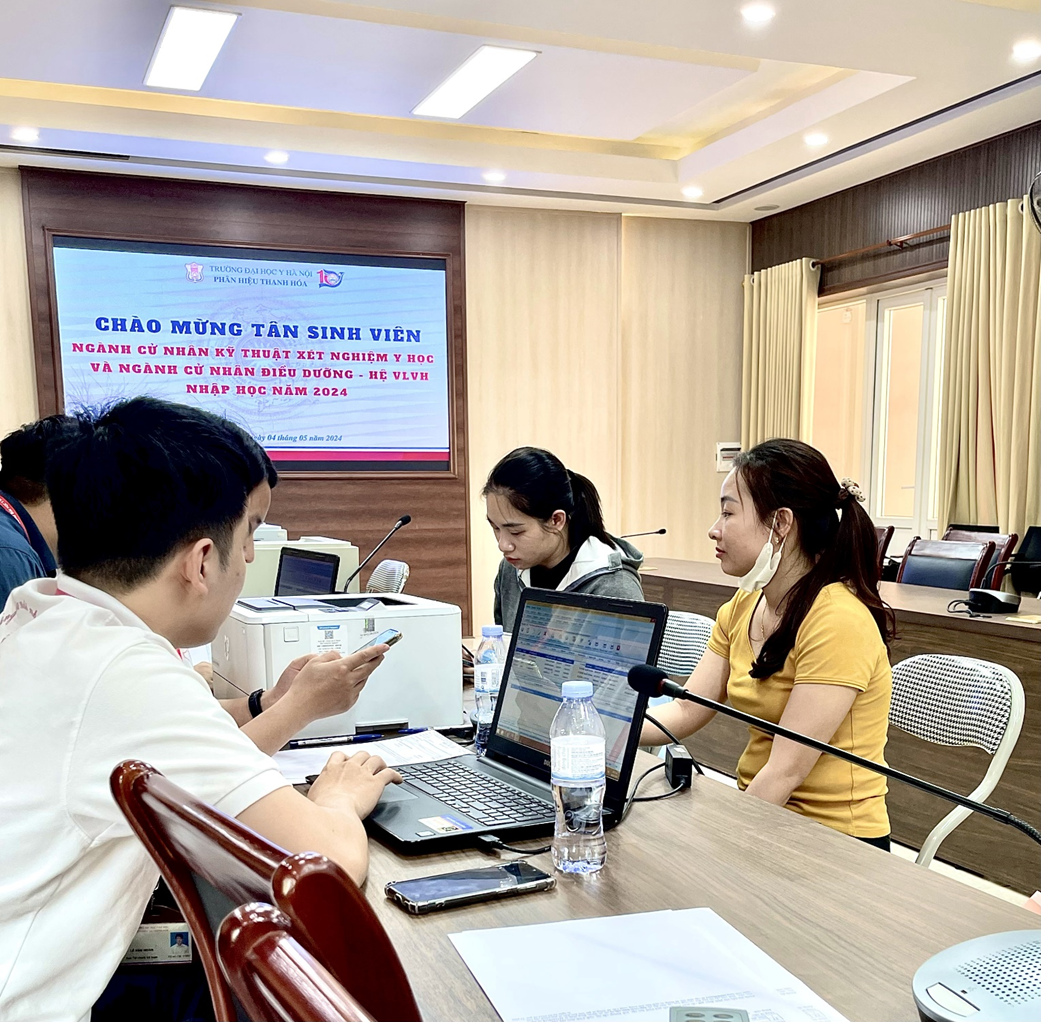 A group of people sitting at a table with laptops

Description automatically generated